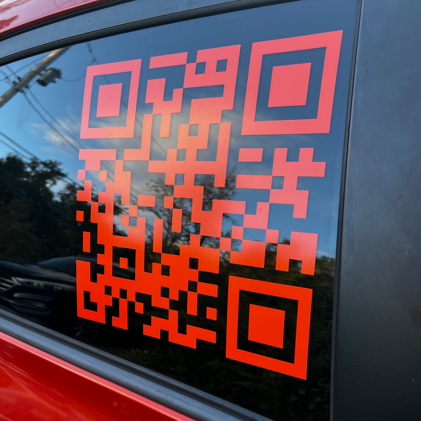 A photo showcasing a orange QR code decal. This image is meant to display what the QR code could look like on a window.