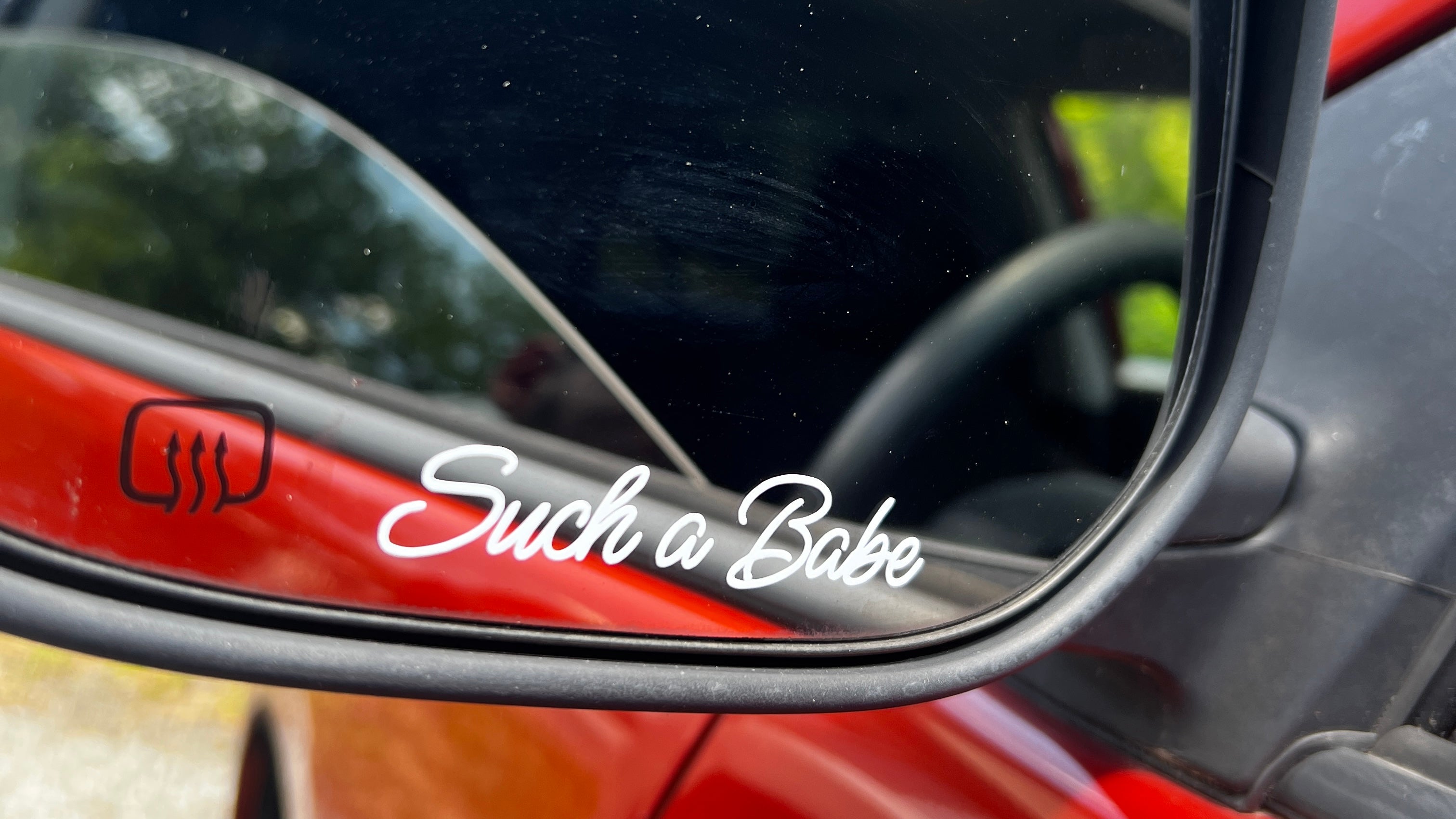 A car's left side mirror showcasing "Such a Babe" in a script font. This is a custom decal example.