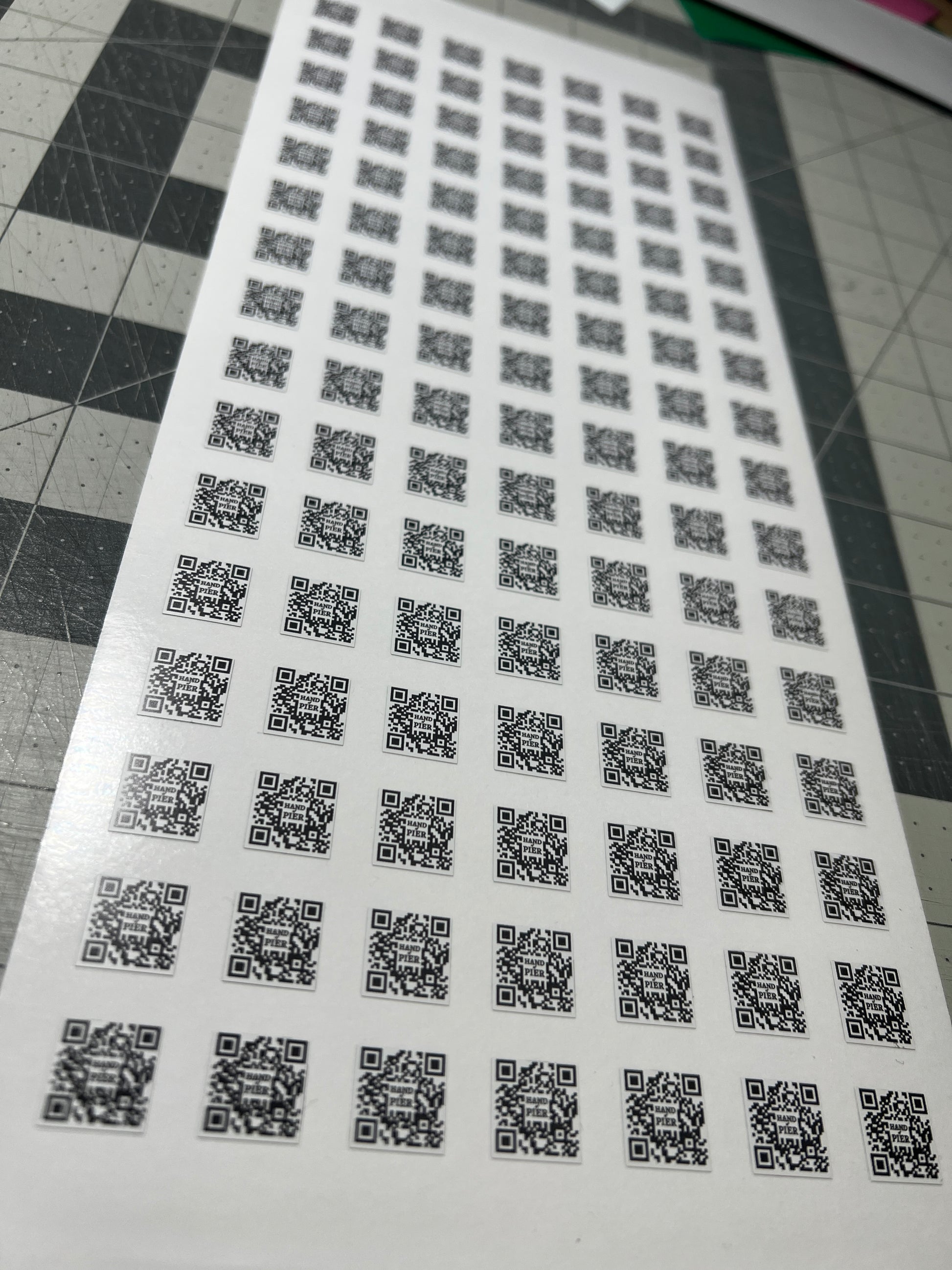 A picture of a sheet of die cut QR codes.