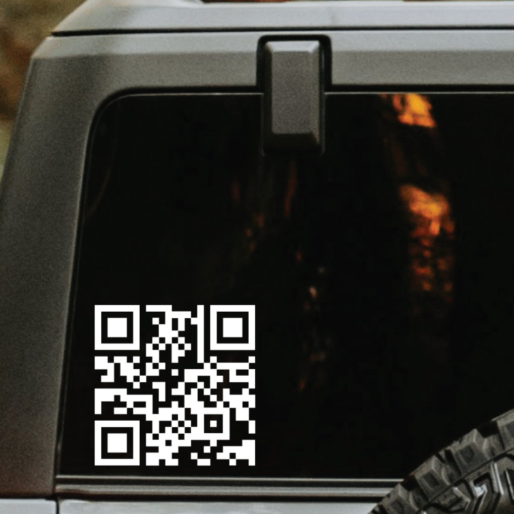 A picture of a vehicle's back window that is tinted and applied to it is a white QR code decal.